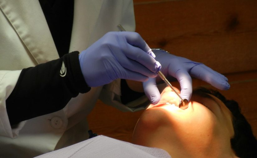 Implantolog-stomatolog przeprowadza badanie dentystyczne